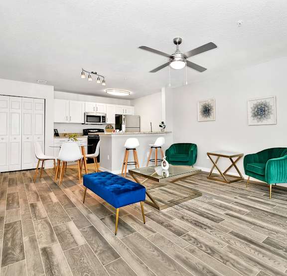 a living room with a ceiling fan and a dining room table with chairs